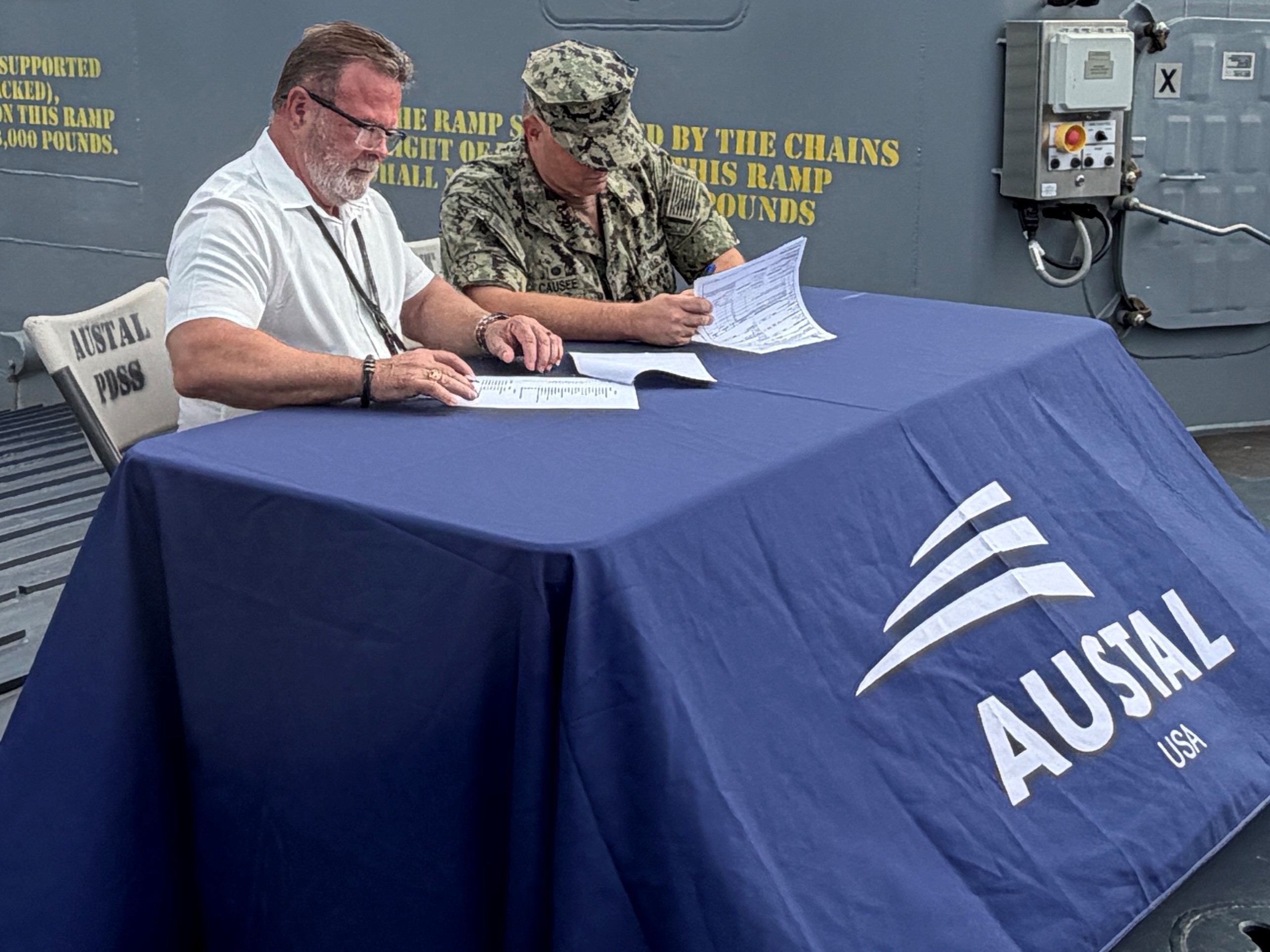 CAPT Christopher Causee and Mike Sleeper, SUPSHIP Gulf Coast Project Manager, sign delivery paperwork for LCU 1710