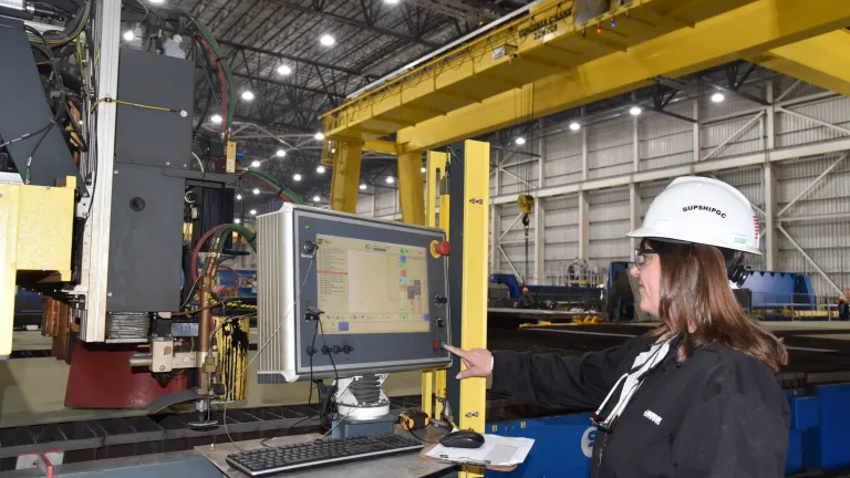 Kathy Sanders, LCU Test Coordinator for Navy Supervisor of Shipbuilding Gulf Coast, pushes button on plasma cutter to begin construction on LCU 1713